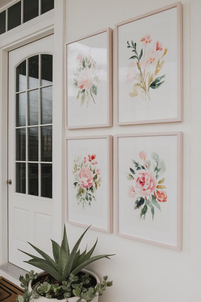 Four framed watercolor floral artworks hang near a door, above a potted plant in a bright, elegant setting.